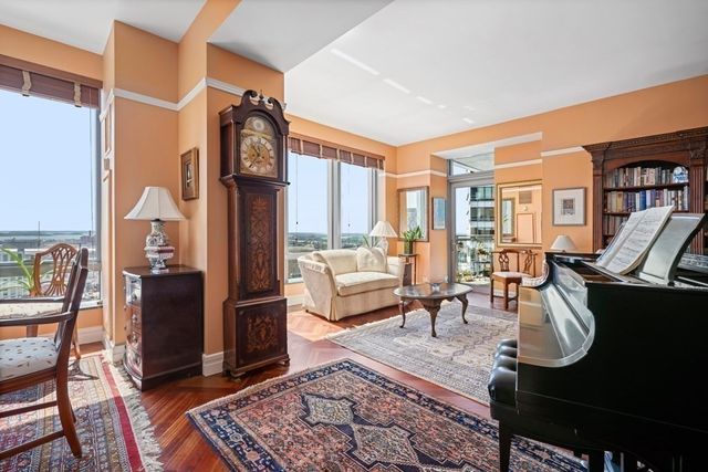 a living room with furniture a rug and a large window