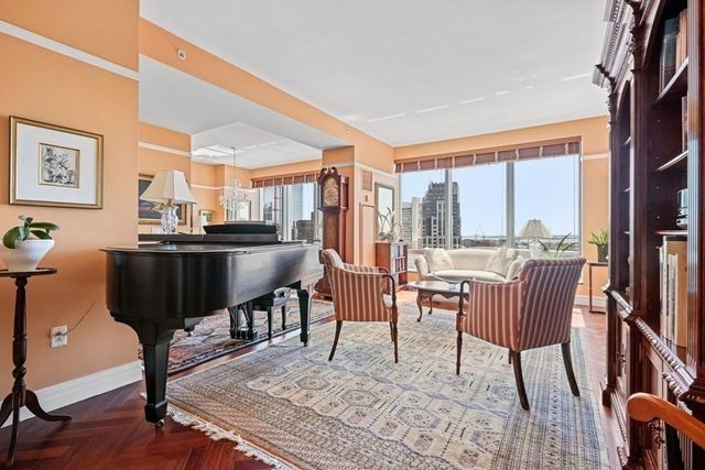 a dining room with furniture a rug and a floor to ceiling window