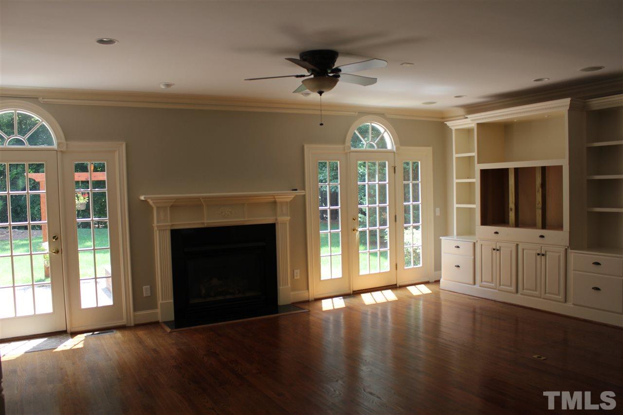 11020 Brass Kettle Road Raleigh, NC 27614 - Photo 5 of 25 Family Room with gas log fireplace, bookshelves, French doors with sidelights and half round windows above.