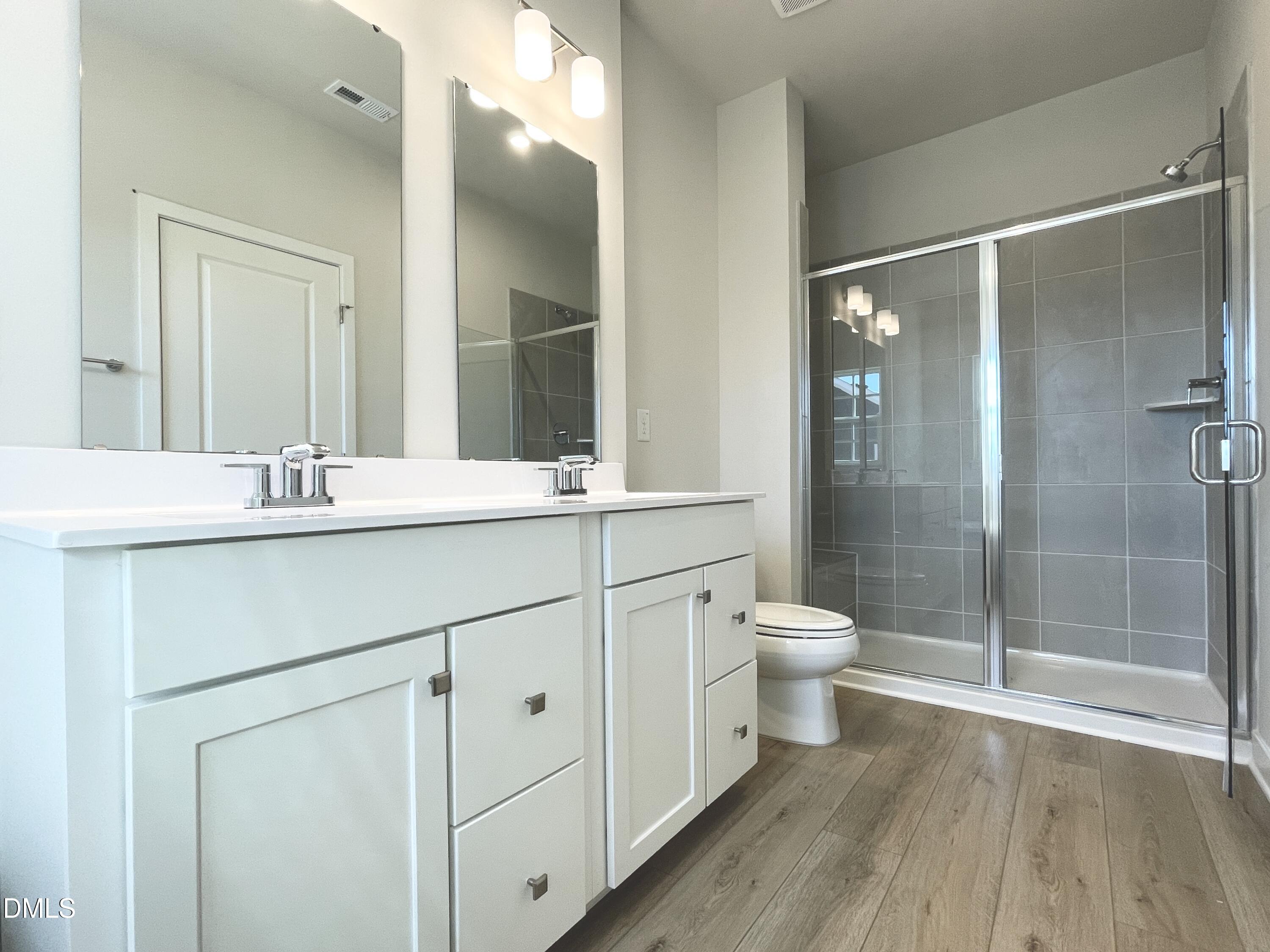 2305 Pitchfork Lane Durham, NC 27713 - Photo 23 of 27 a bathroom with a double vanity sink toilet and shower