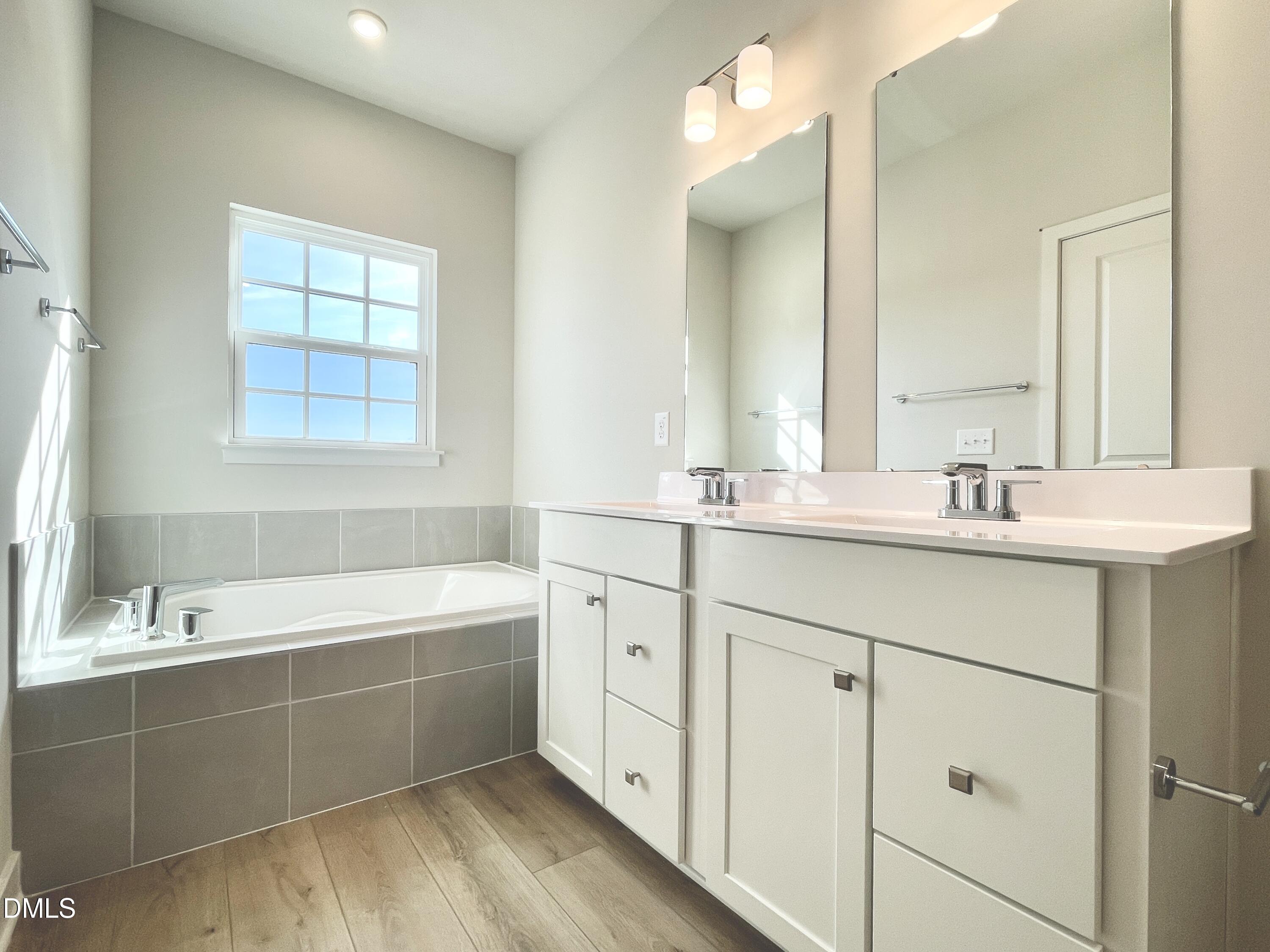 2305 Pitchfork Lane Durham, NC 27713 - Photo 24 of 27 a bathroom with a double vanity sink mirror and a bathtub