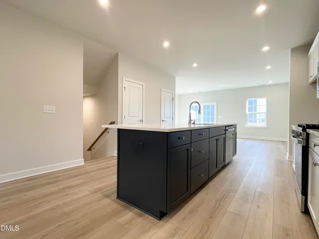 a view of an empty room with wooden floor and window