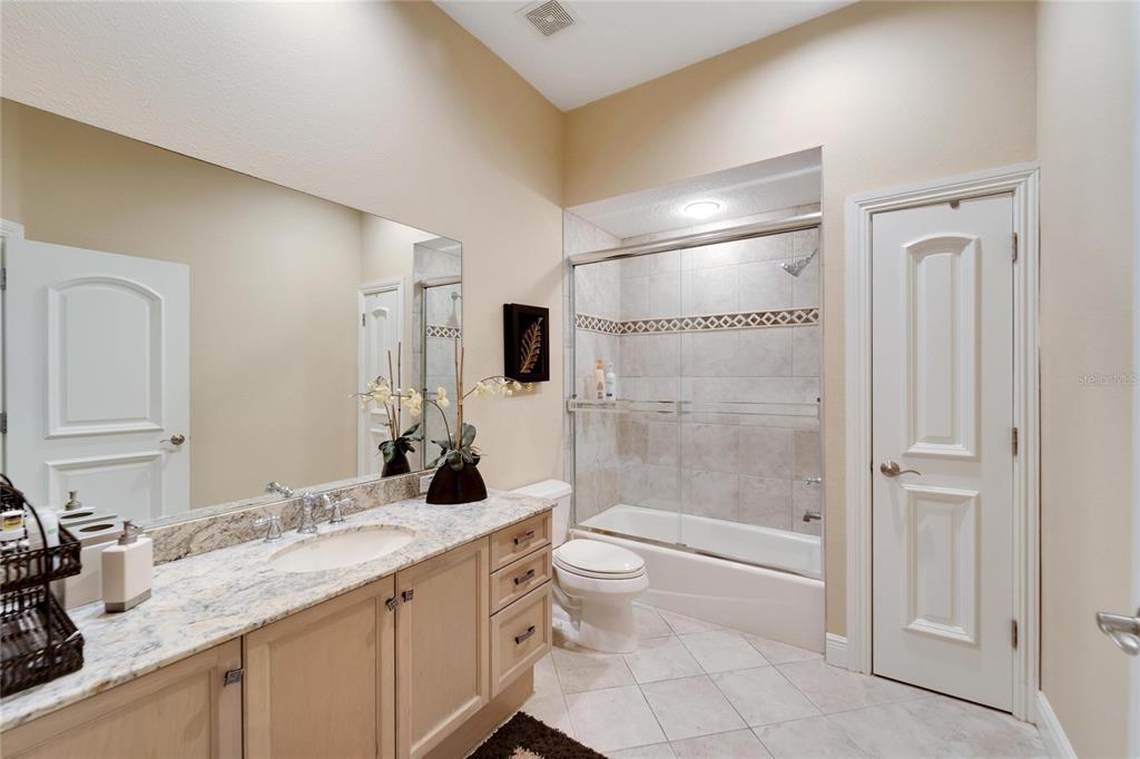 15101 Kestrelglen Way Lithia, FL 33547 - Photo 51 of 75 a bathroom with a granite countertop sink a toilet a mirror and shower