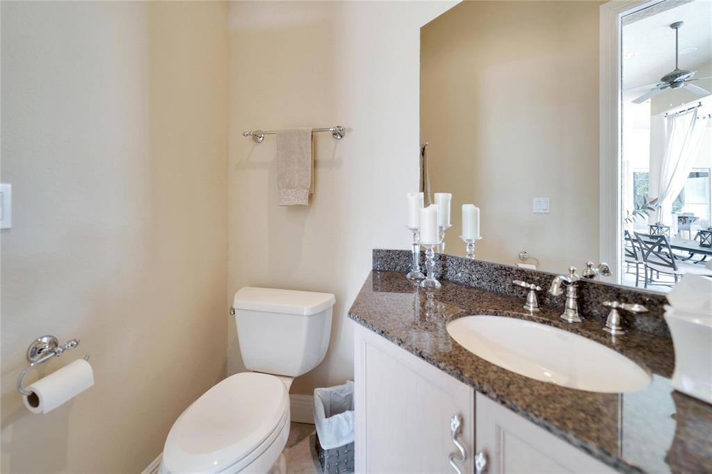 15101 Kestrelglen Way Lithia, FL 33547 - Photo 62 of 75 a bathroom with a granite countertop toilet a sink and a mirror