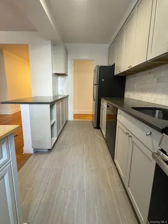 a kitchen with a refrigerator a stove top oven a sink and dishwasher with wooden floor