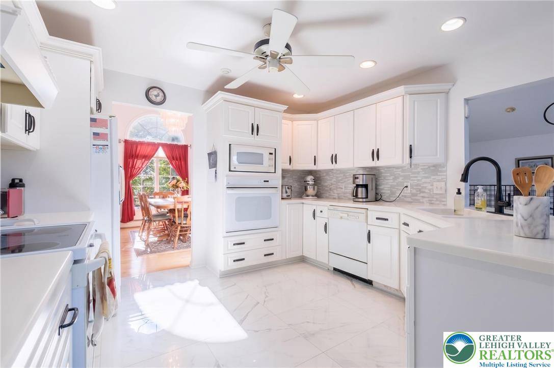 1089 Deemer Road Bath, PA 18014 - Photo 14 of 57 This bright kitchen features sleek white cabinetry and appliances, alongside durable tile flooring.