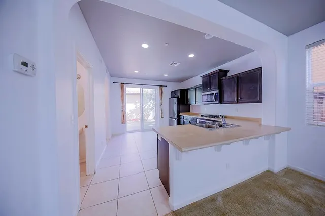 a view of kitchen with cabinets and window