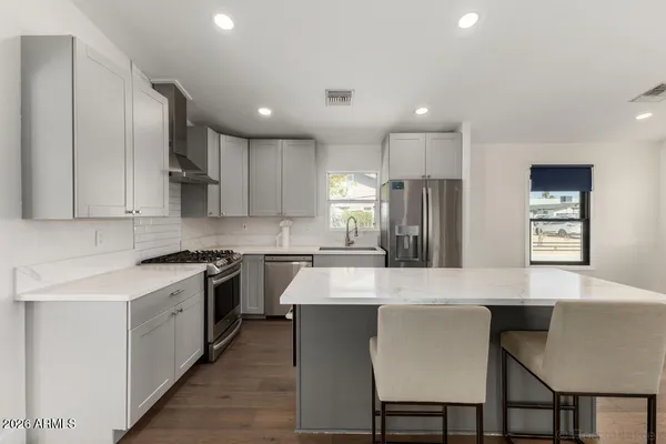 a large kitchen with cabinets table and chairs