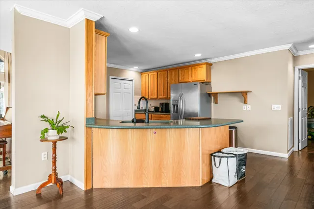 a kitchen with stainless steel appliances granite countertop a refrigerator stove top oven with a sink and dishwasher