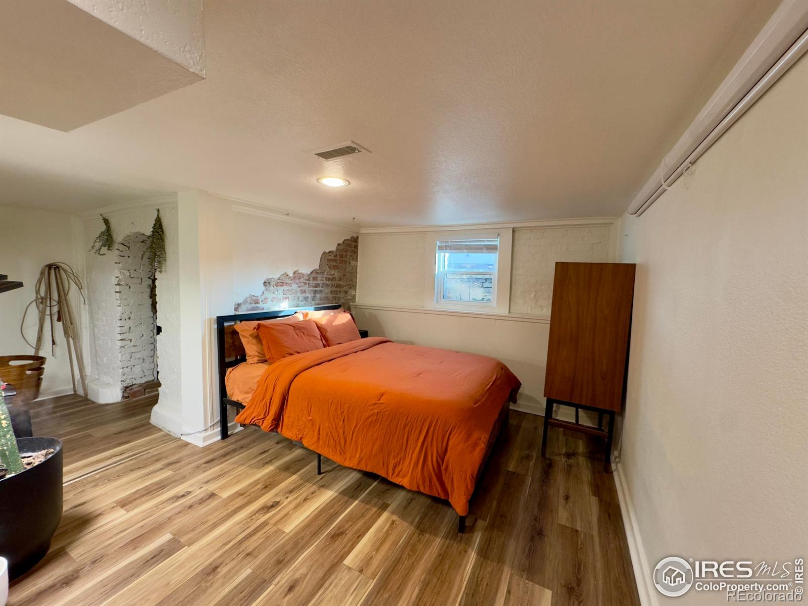 610 Logan Street, Unit 7 Denver, CO 80203 - Photo 14 of 19 a bedroom with a bed and wooden floor