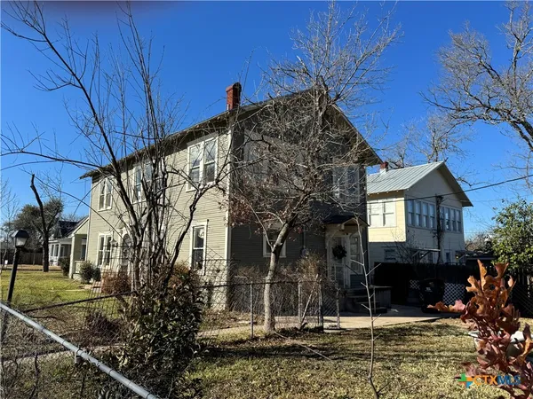 a view of a house with a tree in front of it