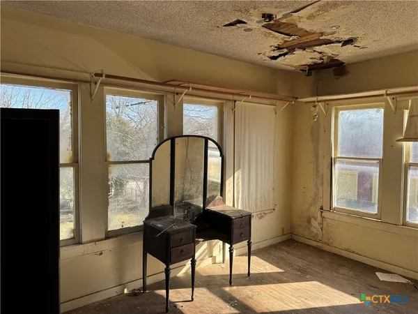 a living room with a bed furniture and a window