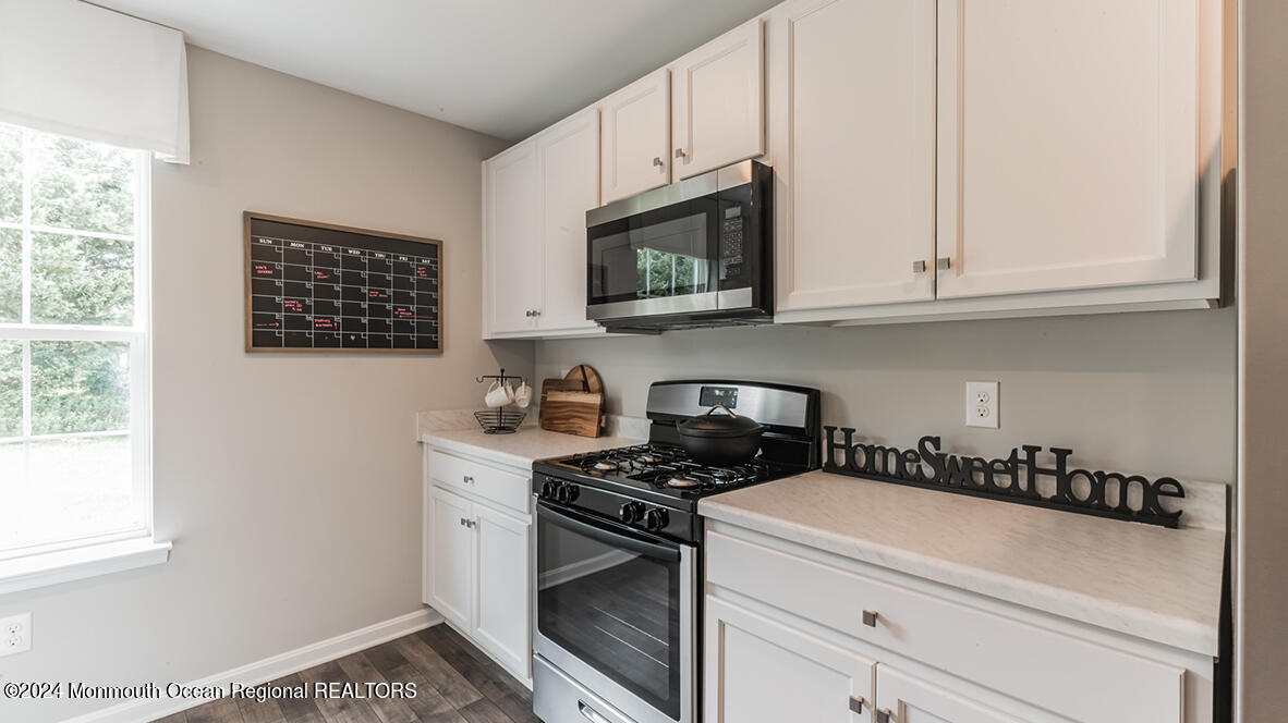 124 West 4th Street Howell, NJ 07731 - Photo 12 of 25 a kitchen with stainless steel appliances white cabinets and a stove top oven