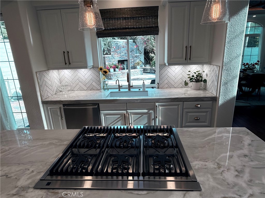 32 Marisol Newport Coast, CA 92657 - Photo 18 of 61 a kitchen with granite countertop a stove a sink and a table