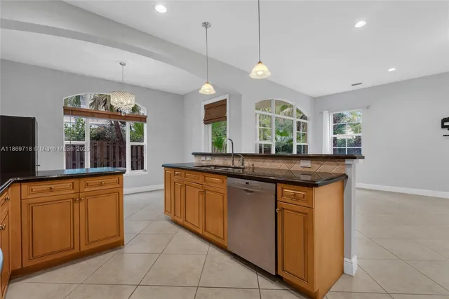 a kitchen with granite countertop a sink and a dishwasher