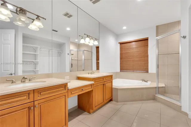 a spacious bathroom with a sink double vanity mirror and a bathtub