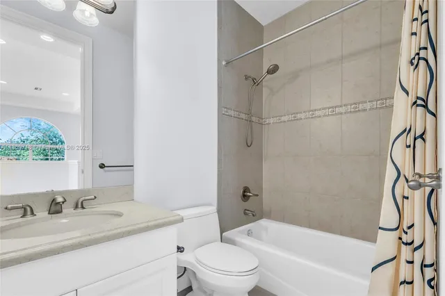 a bathroom with a granite countertop sink a toilet and shower