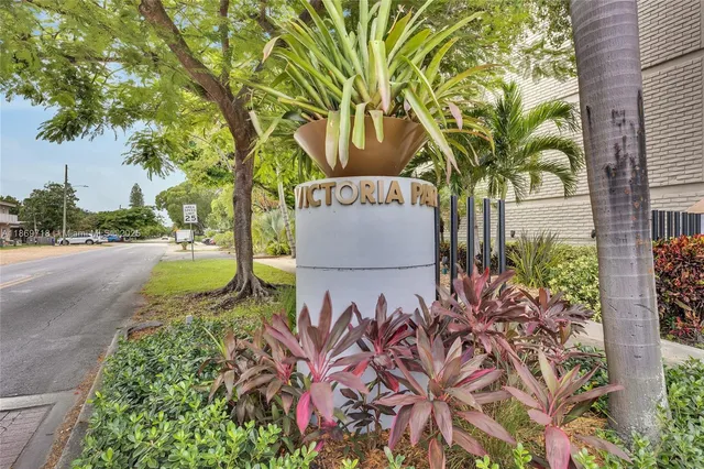 a sign that is sitting in front of a brick house