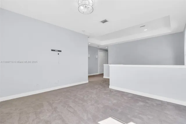 a view of a yard with plants and large trees