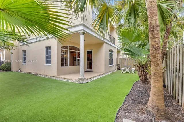 a view of a house with a yard and potted plants