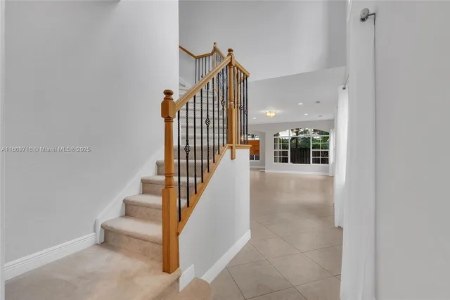 a view of staircase with railing and white walls