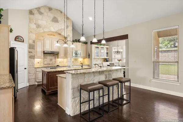 a kitchen with kitchen island granite countertop wooden floors and white cabinets