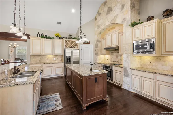 a kitchen with granite countertop a sink stove and cabinets