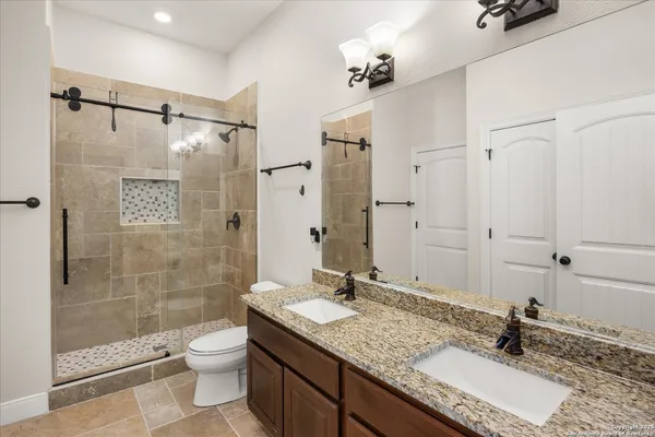 a bathroom with a granite countertop sink toilet and shower