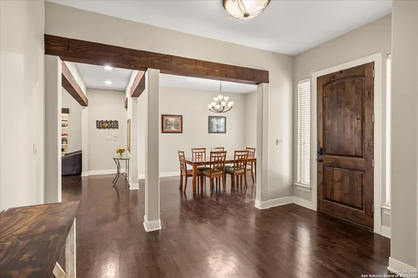 a view of a hallway with wooden floor and dining room