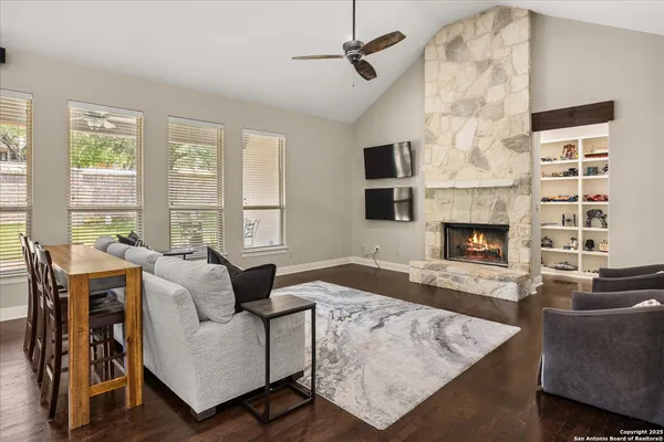 a living room with furniture a flat screen tv and a fireplace