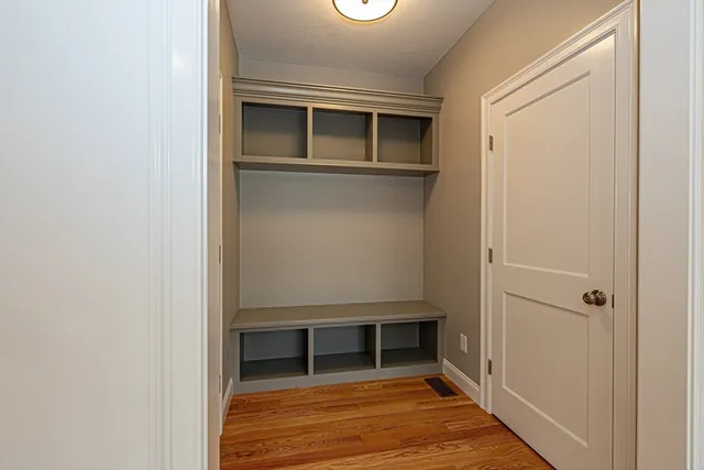 a view of empty room with wooden floor and cabinet