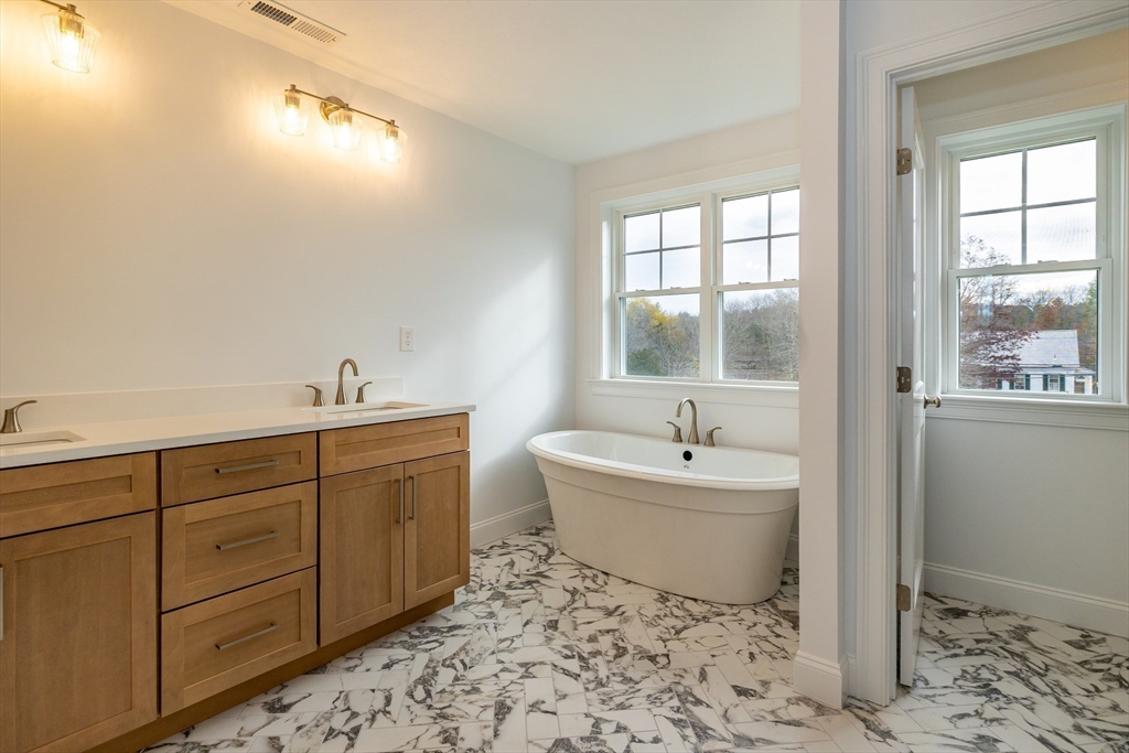 254 Concord Road, Unit LOT 2A Westford, MA 01886 - Photo 23 of 29 a bathroom with a sink and mirror with bathtub