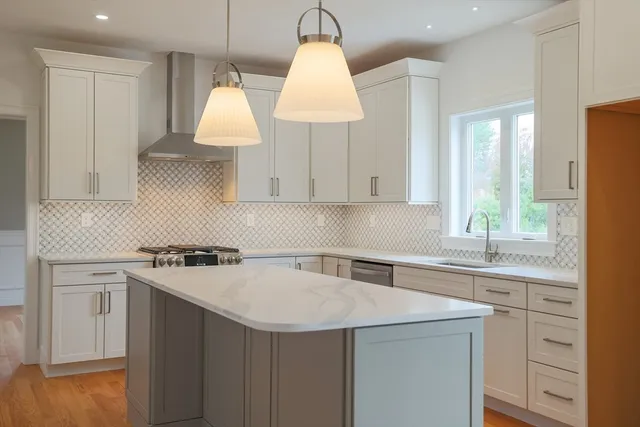 a kitchen with a sink a stove a window and cabinets