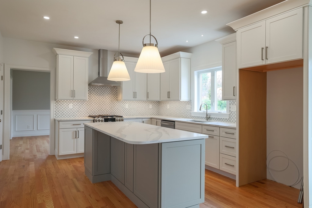 254 Concord Road, Unit LOT 2A Westford, MA 01886 - Photo 8 of 29 a kitchen with stainless steel appliances granite countertop a sink a stove a refrigerator and island with wooden floor
