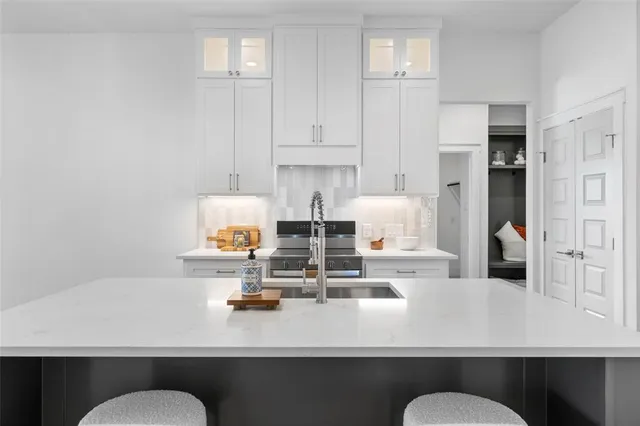 a kitchen with sink stove and wooden floor