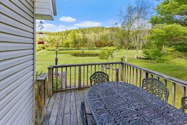a view of a balcony with wooden floor next to a yard