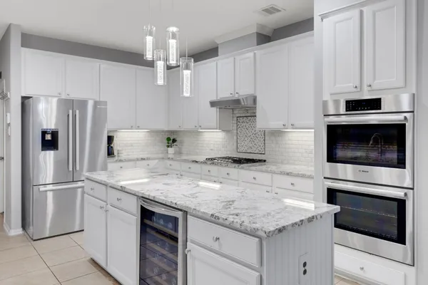 a kitchen with granite countertop a sink stainless steel appliances and counter space