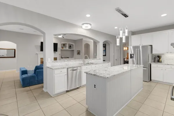 a kitchen with granite countertop a sink and white cabinets