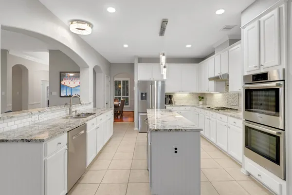 a large kitchen with granite countertop a sink and cabinets