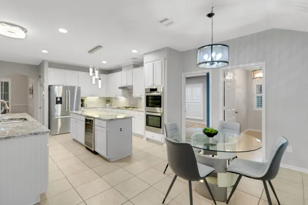 a kitchen with stainless steel appliances kitchen island granite countertop a table and chairs in it