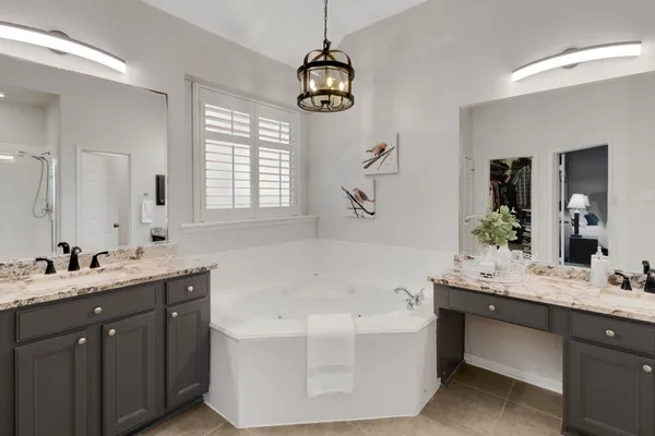 a bathroom with a tub sink and mirror