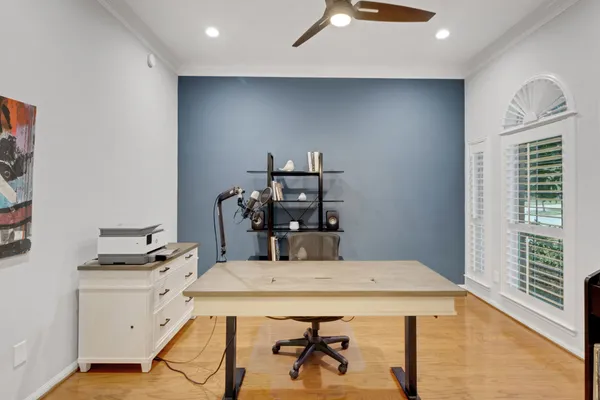 a living room with furniture a dining table and a bookshelf with wooden floor
