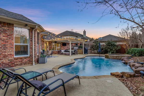 a view of a backyard with swimming pool and sitting area
