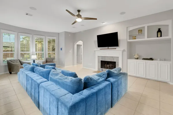 a living room with furniture a flat screen tv and a fireplace