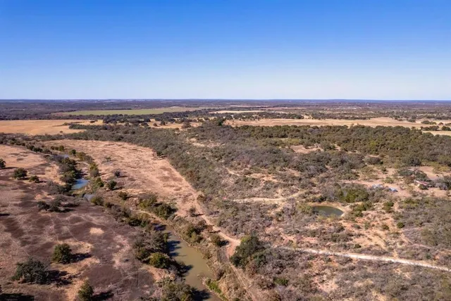 a view of a dry yard with mountains in the background