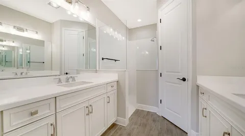 a spacious bathroom with a shower sink and mirror