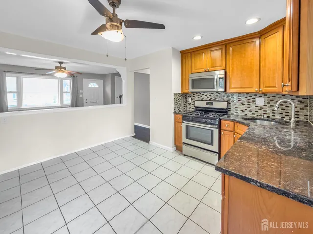 a kitchen with stainless steel appliances granite countertop a stove a sink and a microwave