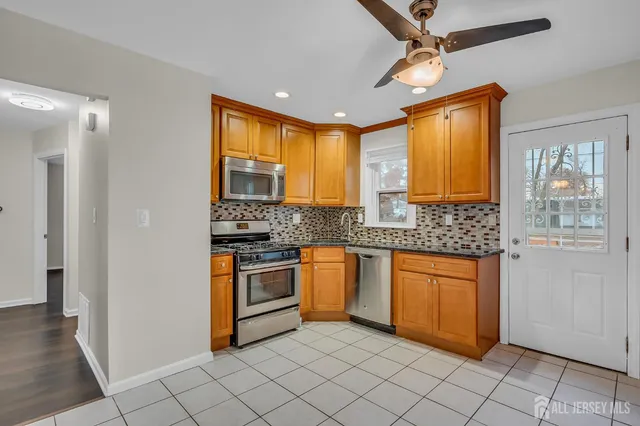 a kitchen with stainless steel appliances granite countertop a stove sink and cabinets