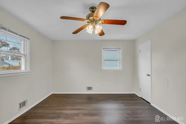 a view of a room with wooden floor and white walls