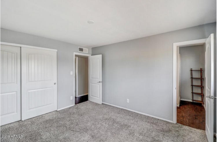 3249 West Citrus Way Phoenix, AZ 85017 - Photo 18 of 22 a view of an empty room and closet with wooden floor